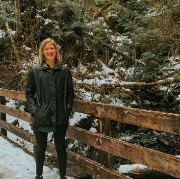 Photo of board member Rebecca Hall standing on a snowy trail.